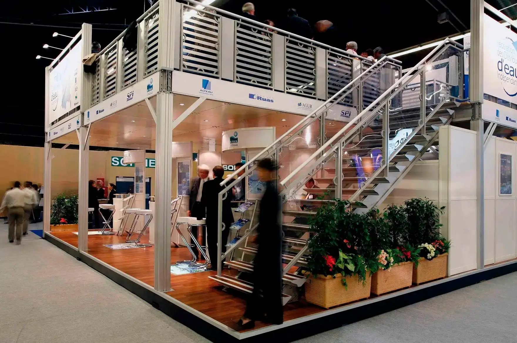 Modern two-story trade show stand attracting visitors with immersive lighting and digital screens
